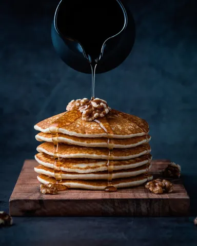 호두를 올린 팬케이크에 꿀을 붓는 모습